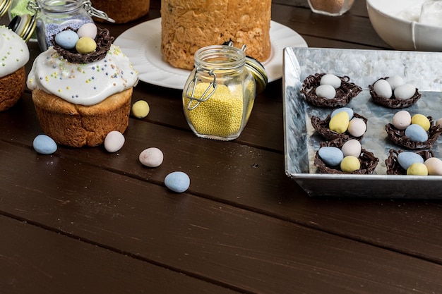 Several traditional cakes and candy eggs on dark background decorated homemade pastry top view