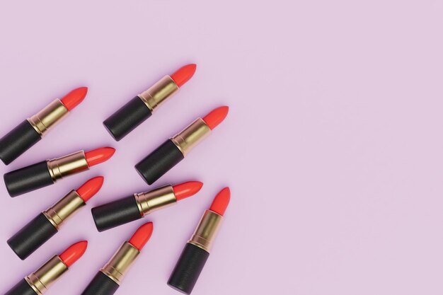 Several tubes of red lipstick on a pink pastel background copy paste copy space 3D render