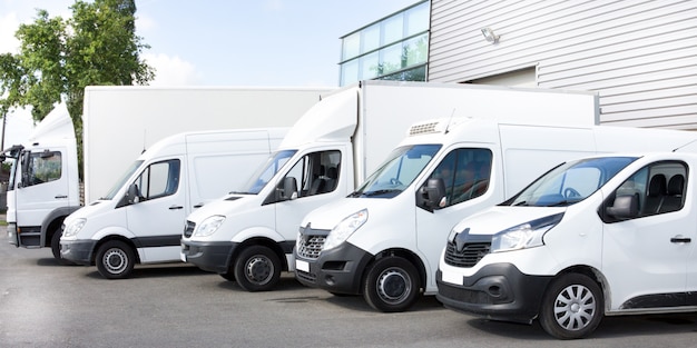 Several vans and trucks parked in parking lot for rent