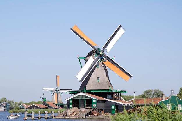 Фото Несколько ветряных мельниц zaanse schans на фоне голубого неба нидерланды