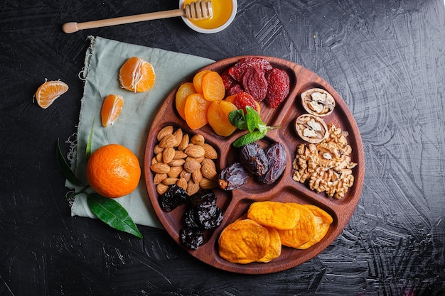 Photo several wooden tray, menagerie with dried fruits, nuts, sausages with cheese, grapes with biscuit