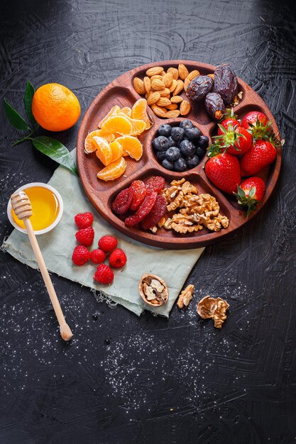 several wooden tray, menagerie with dried fruits, nuts, sausages with cheese, grapes with biscuit