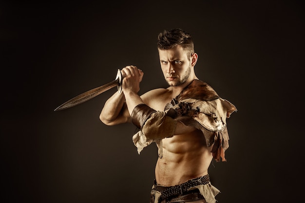 Severe barbarian in leather costume with sword