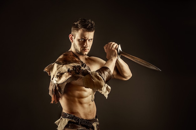 Severe barbarian in leather costume with sword