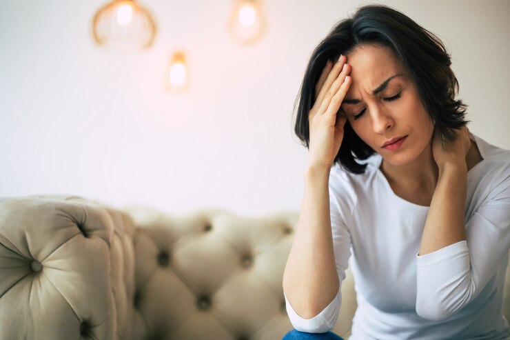 Photo severe pain. close-up photo of a beautiful woman, who is touching her forehead and the back of her neck, while suffering from headache.