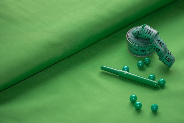 Seving accessories in green tones on a fabric background