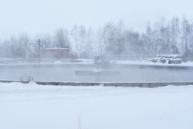 Sewage treatment plant in winter, icy primary settling tanks