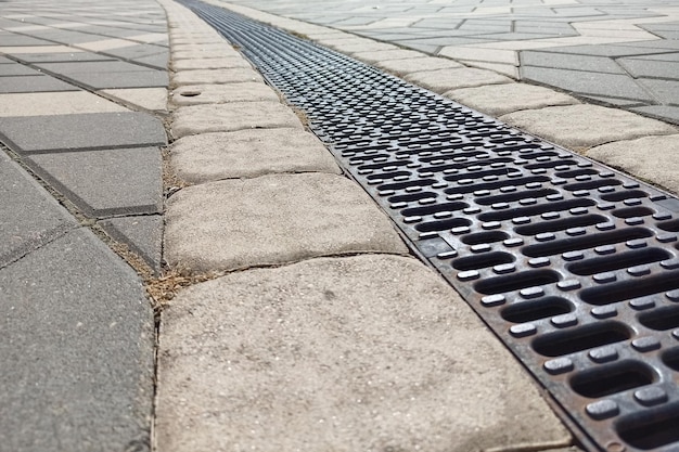 Sewer drain grate on the sidewalk closeup