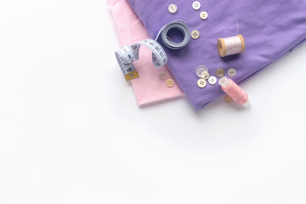 Sewing accessories and fabric on a white background