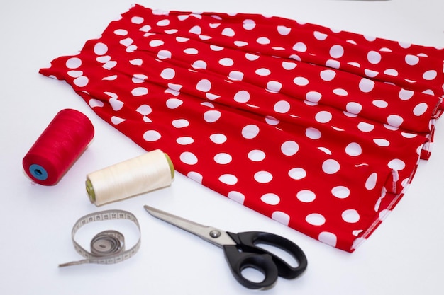 Sewing accessories and fabric on wooden background