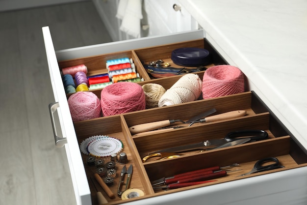 Sewing accessories in open desk drawer indoors