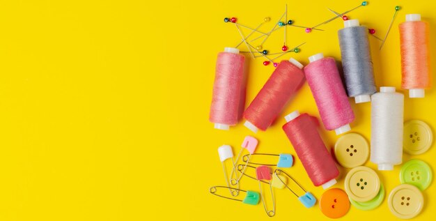 Sewing accessories on a yellow background closeup copy space