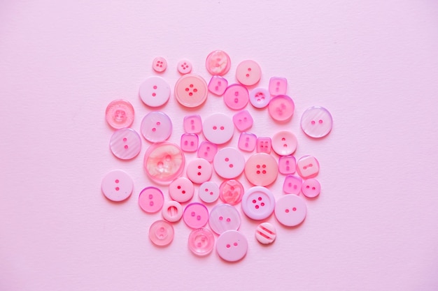 Sewing Buttons composition on pink