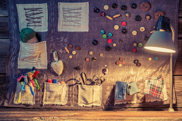 Sewing cloth with scissors threads and needles in tailor workshop