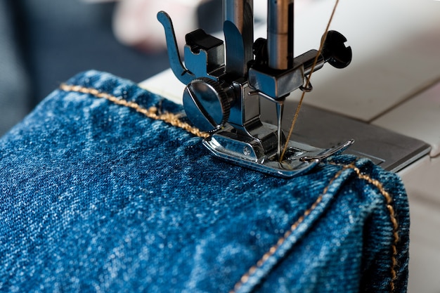 Sewing indigo denim jeans with sewing machine, garment industrial concept.
