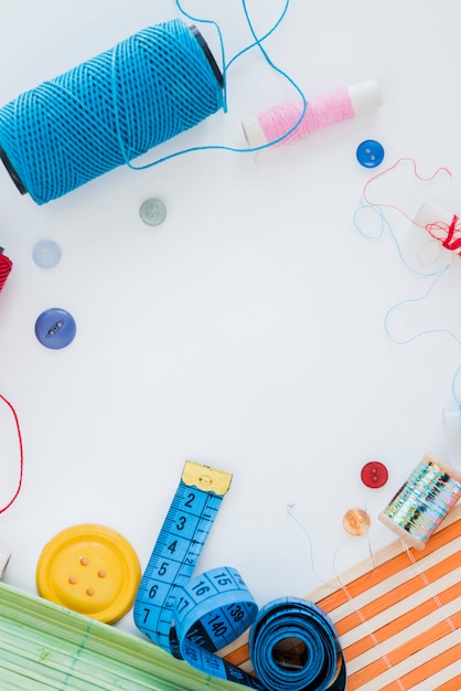 Sewing items layout on white desk