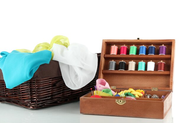 Sewing kit in wooden box and basket with cloth isolated on white