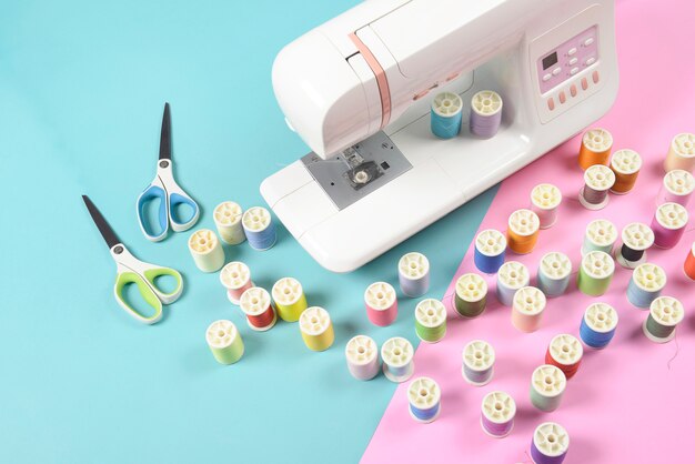 Швейная машина и красочные рулонные нитки для шитья, концепция шитья и рукоделия.