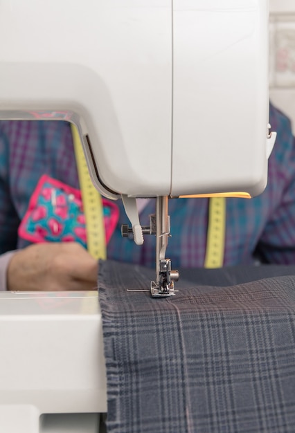 Sewing machine needle and seamstress on backgroud
