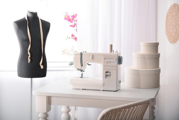 Photo sewing machine on table in tailors workshop