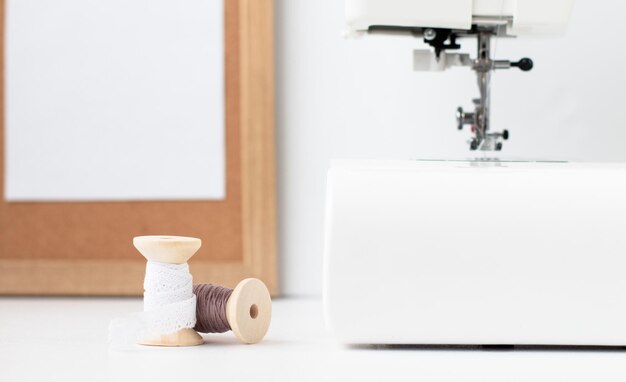 sewing machine and two spools of thread on a white background