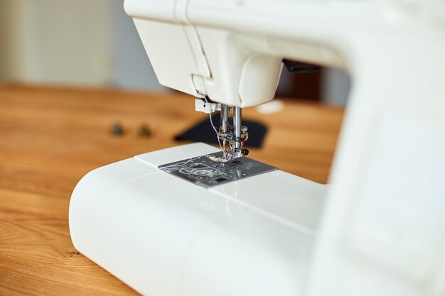 Sewing machine on a wooden table, copy space. Close up.