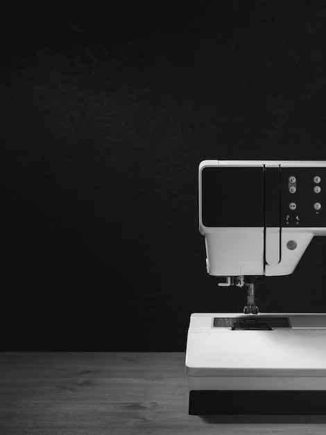 Sewing machine on a work desk black and white photo Black background