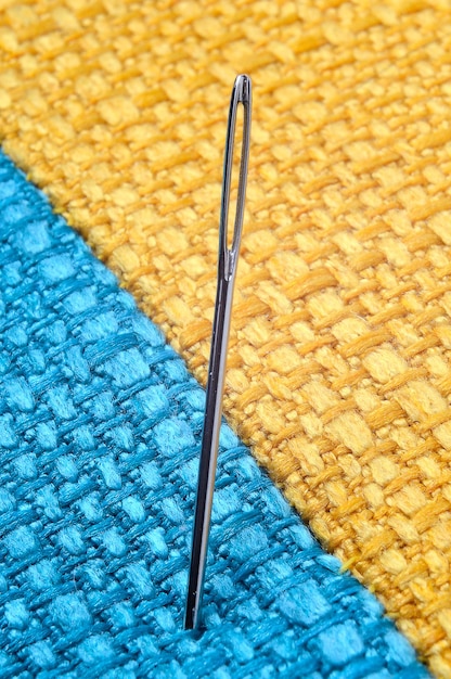 Sewing needle on a yellow fabric background. close-up.