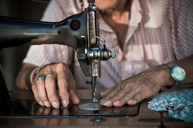 Sewing Process by the vintage sewing machine on old man designer blur background