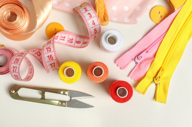 Sewing supplies on white background, top view