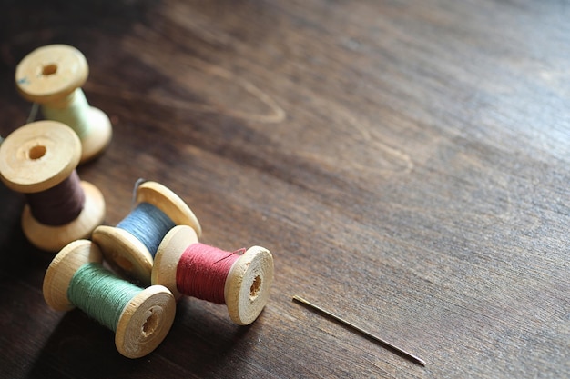 Sewing thread on a wooden background Set of threads on bobbins retro style Vintage accessories for sewing on the table