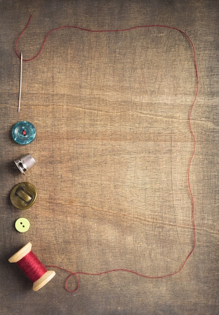 Strumenti e accessori per cucire su sfondo di tavolo in legno, vista dall'alto