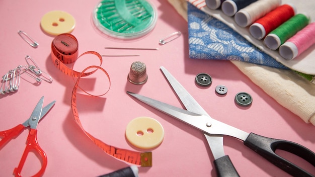 Sewing tools on the pink paper background