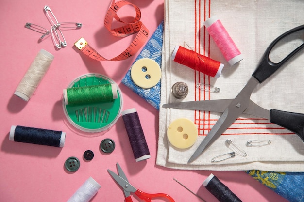 Sewing tools on the pink paper background