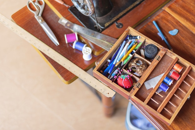 Швейные инструменты и катушки цветной нити на столе