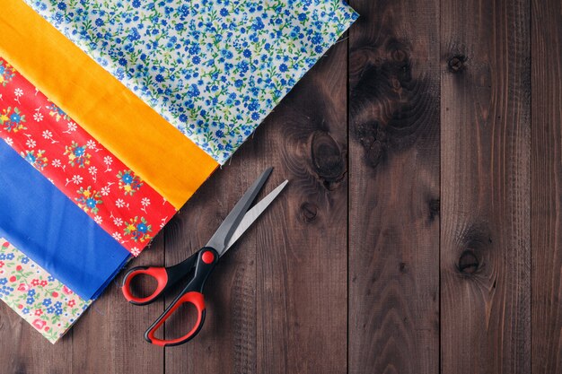 Sewing tools and sewing kit on wooden textured background