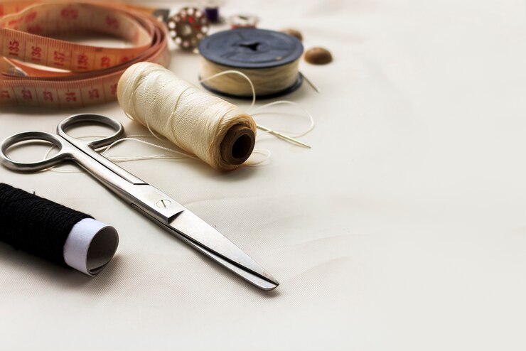 Photo sewing tools on white fabric background