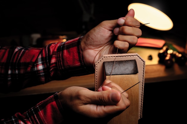 Sewing the vegetable tanned leather by hand. Leather and the craft tools.