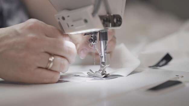 Фото Шьем белую ткань на белой швейной машине крупным планом женские руки