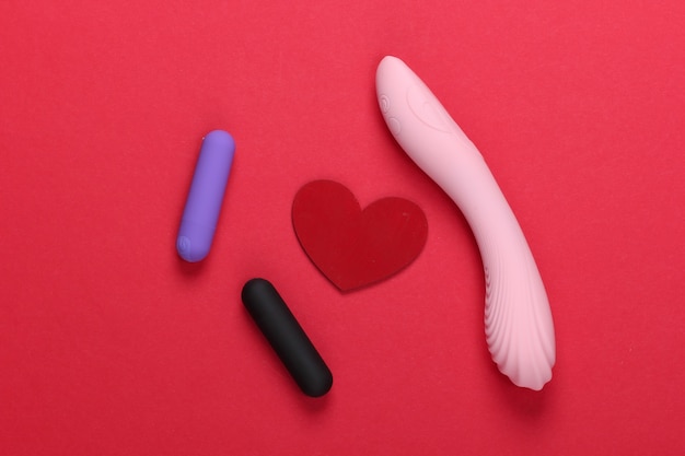 Sex concept. Sex toys and red heart on red