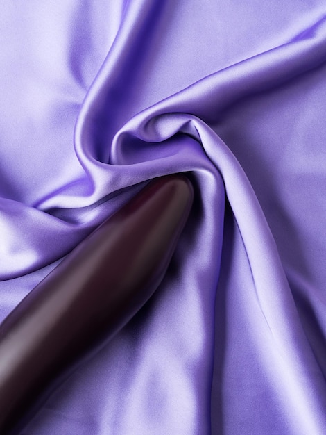 Photo sex and orgasm concept with eggplant on crumpled silk sheet