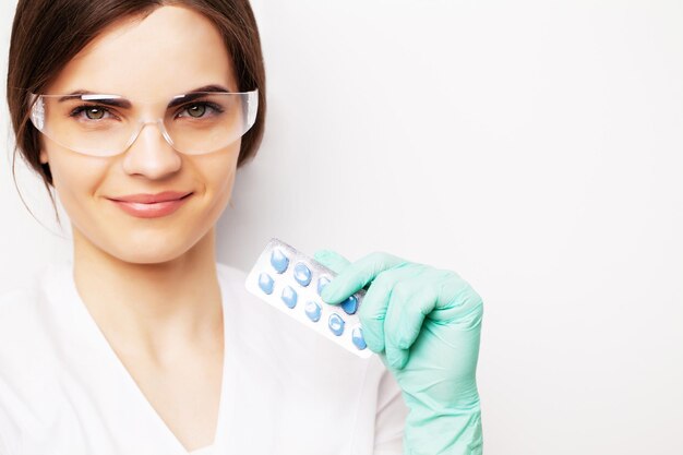 Sexual health, a doctor in a white coat holding a pill for a healthy sex life of men