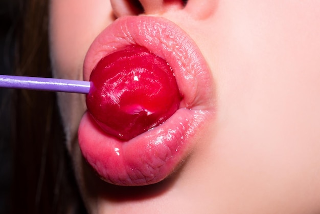 사탕과 섹시한 입술, 섹시한 달콤한 꿈. 여성의 입은 츄파 찹을 핥고 사탕을 빨아 먹습니다.