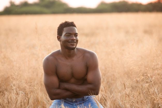 Сексуальный мужчина позирует без рубашки на зерновом поле