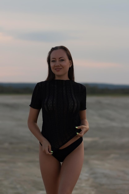 Sexual woman in black outfit on beach