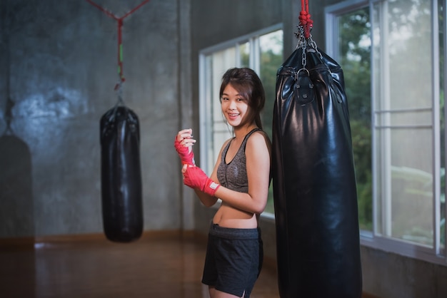 Sexy asia girl punching boxing bag