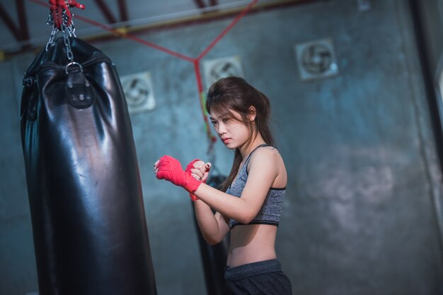 Sexy asia girl punching boxing bag