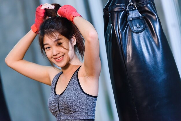 Sexy asia girl punching boxing bag