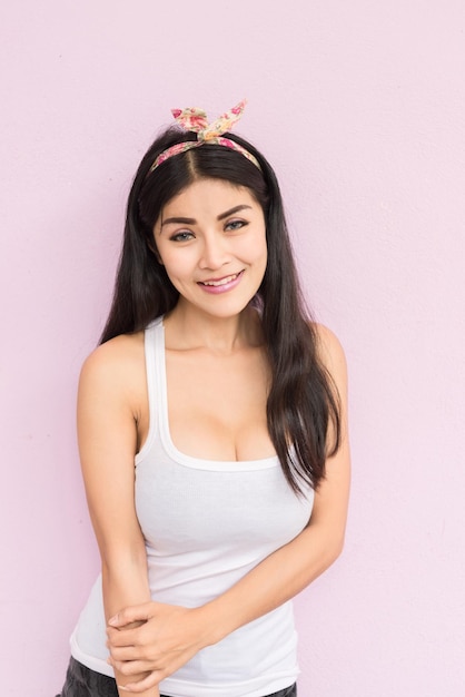 Sexy Aziatische vrouw poseren voor het nemen van een foto op roze achtergrond