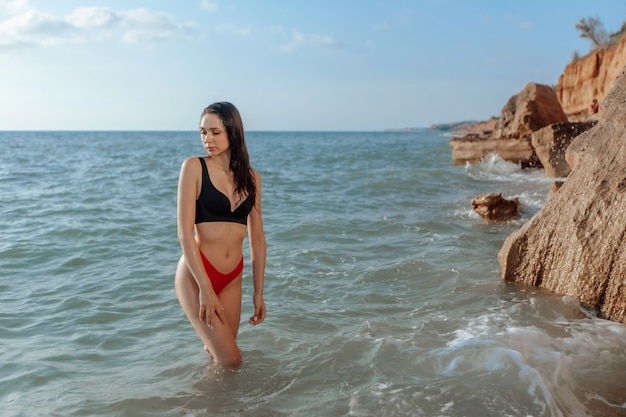 Foto bella ragazza sexy che cammina sulla spiaggia. copia spazio